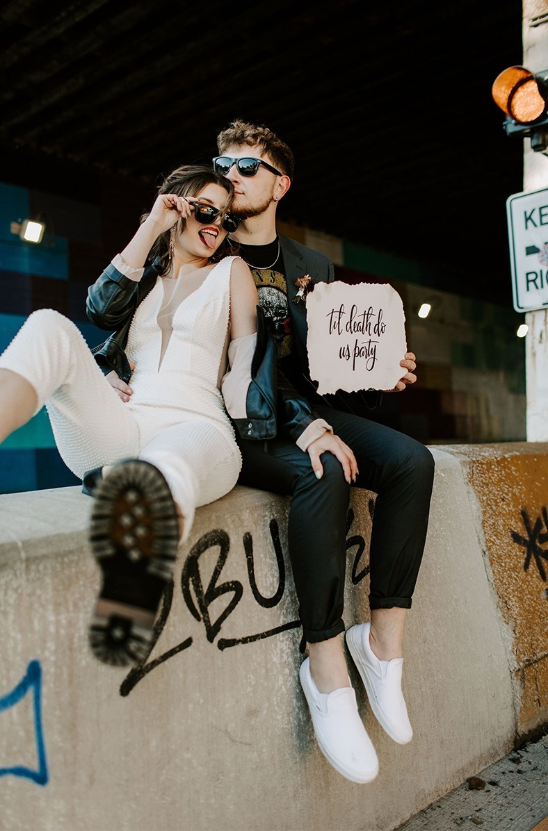 Edgy wedding couple wearing sunglasses and suits.